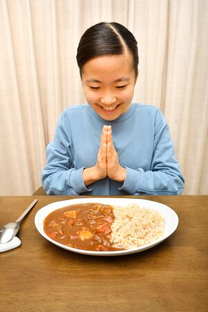 Japanese girl enjoys having curry and riceの写真素材
