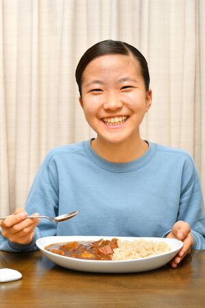 Japanese girl enjoys having curry and riceの写真素材