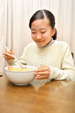 Japanese girl enjoys having buckwheat noodle with deep fried shrimpの写真素材