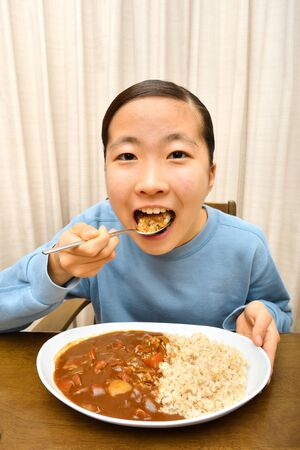 Japanese girl enjoys having curry and riceの写真素材