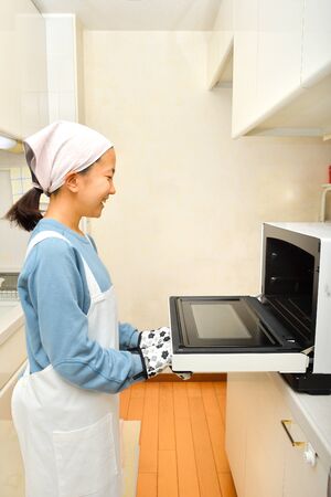 Japanese girl cooking in the kitchenの写真素材