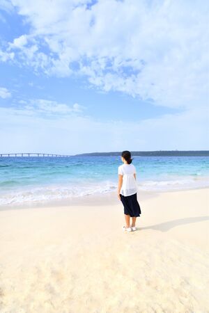 Japanese girl standing in the beach - Okinawa Miyakojima rear viewの写真素材