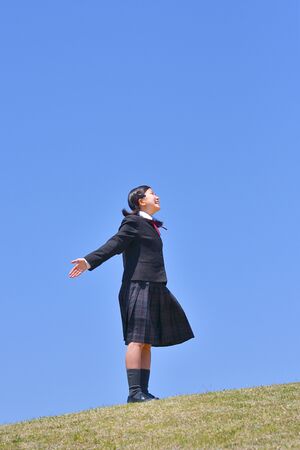 Japanese girl looking up in the blue skyの写真素材