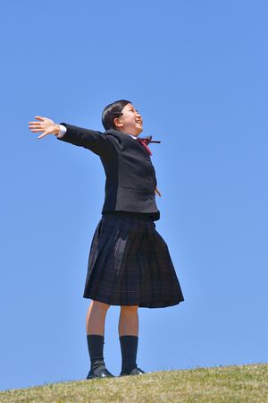 Japanese girl looking up in the blue skyの写真素材