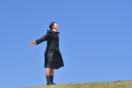 Japanese girl looking up in the blue skyの写真素材