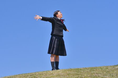 Japanese girl looking up in the blue skyの写真素材