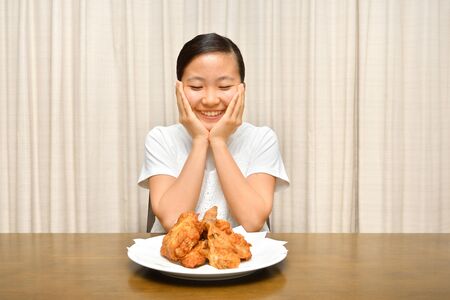 Japanese girl enjoys having fried chickenの写真素材
