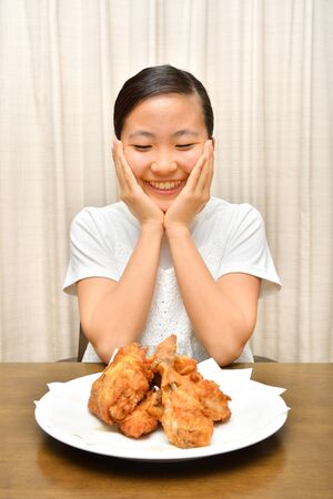 Japanese girl enjoys having fried chickenの写真素材