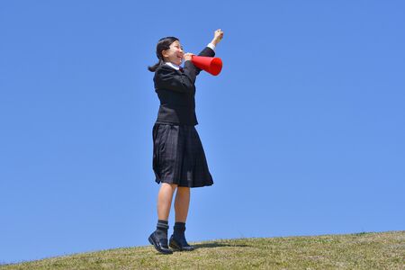 Japanese girl cheering in the blue skyの写真素材