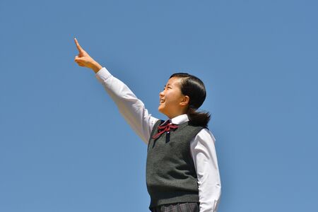 Japanese girl pointing in the blue skyの写真素材