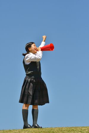 Japanese girl cheering in the blue skyの写真素材