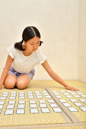 Japanese girl playing Japanese card game on Tatami matsの写真素材