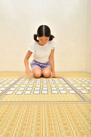 Japanese girl playing Japanese card game on Tatami matsの写真素材