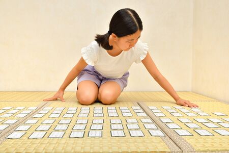 Japanese girl playing Japanese card game on Tatami matsの写真素材