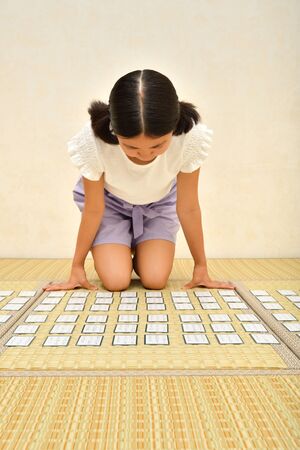 Japanese girl playing Japanese card game on Tatami matsの写真素材