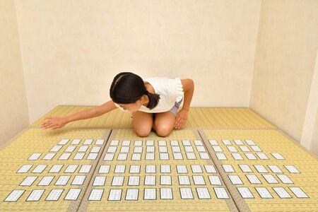 Japanese girl playing Japanese card game on Tatami matsの写真素材