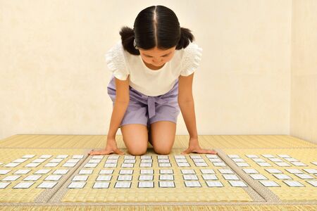 Japanese girl playing Japanese card game on Tatami matsの写真素材