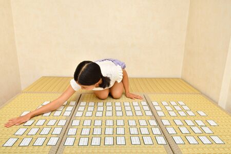 Japanese girl playing Japanese card game on Tatami matsの写真素材