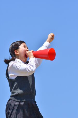 Japanese girl cheering in the blue skyの写真素材