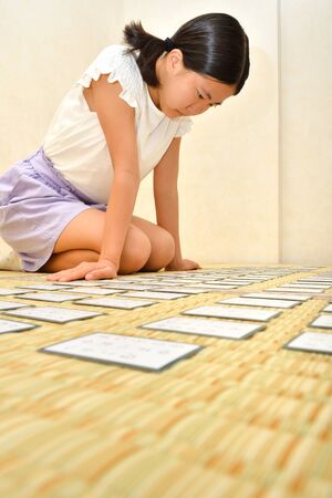 Japanese girl playing Japanese card game on Tatami matsの写真素材
