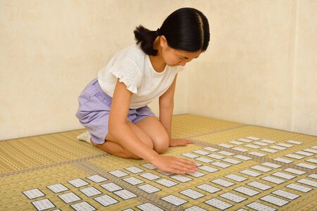 Japanese girl playing Japanese card game on Tatami matsの写真素材