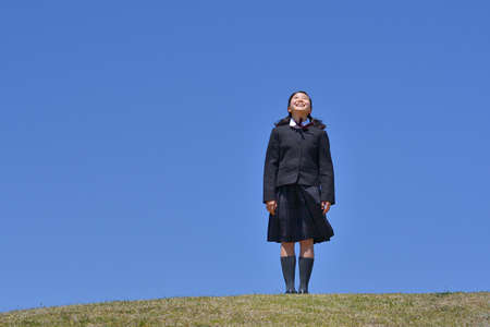 Japanese girl looking up in the blue skyの写真素材