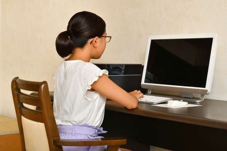 Japanese girl operating personal computerの写真素材