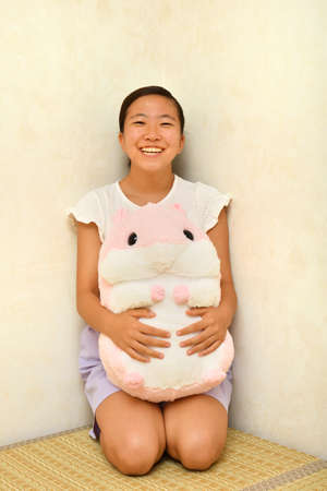 Japanese girl playing with stuffed toy on the Japanese roomの写真素材