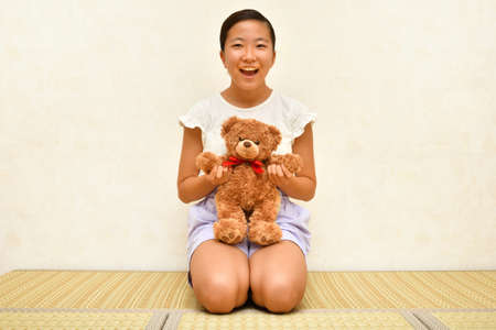 Japanese girl playing with stuffed toy on the Japanese roomの写真素材