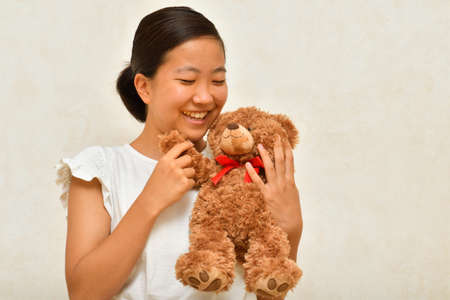 Japanese girl playing with stuffed toyの写真素材