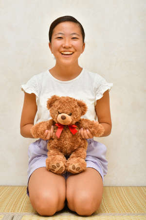 Japanese girl playing with stuffed toy on the Japanese roomの写真素材