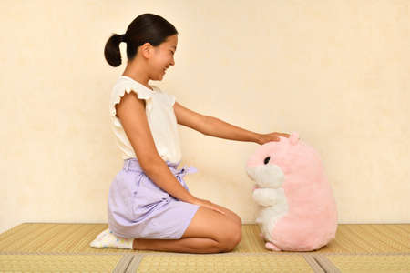 Japanese girl playing with stuffed toy on the Japanese roomの写真素材