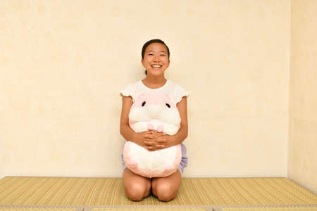 Japanese girl playing with stuffed toy on the Japanese roomの写真素材