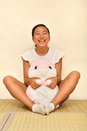 Japanese girl playing with stuffed toy on the Japanese roomの写真素材