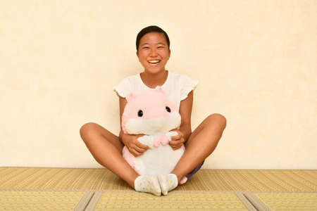 Japanese girl playing with stuffed toy on the Japanese roomの写真素材