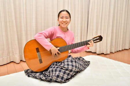 The girl playing the  acoustic guitarの写真素材