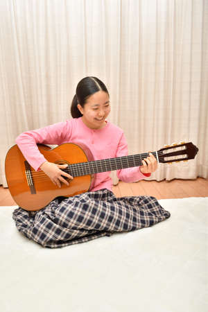 The girl playing the  acoustic guitarの写真素材