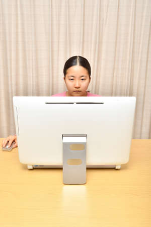 Japanese girl operating personal computer in the living roomの写真素材