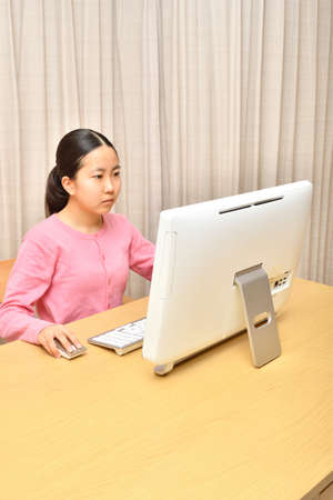 Japanese girl operating personal computer in the living roomの写真素材