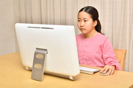 Japanese girl operating personal computer in the living roomの写真素材