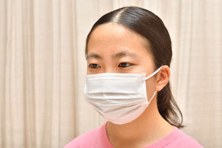 Japanese girl wearing mask not to suffer illnessesの写真素材