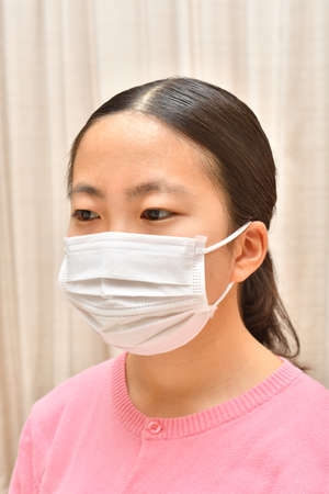 Japanese girl wearing mask not to suffer illnessesの写真素材