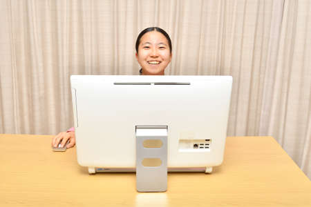 Japanese girl operating personal computer in the living roomの写真素材