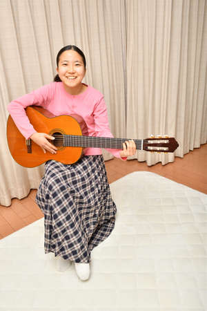 The girl playing the acoustic guitarの写真素材