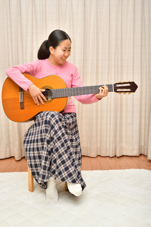 The girl playing the acoustic guitarの写真素材