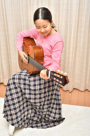 The girl playing the acoustic guitarの写真素材