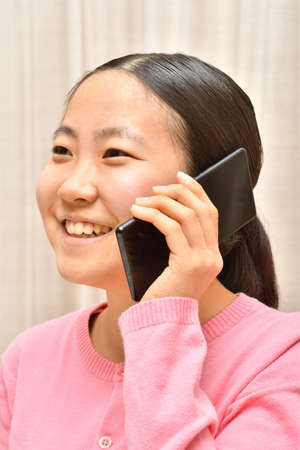 Japanese girl enjoys talking on the phoneの写真素材