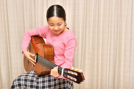 The girl playing the  acoustic guitarの写真素材