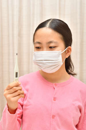 Japanese girl wearing mask not to suffer illnessesの写真素材