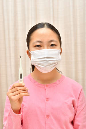 Japanese girl wearing mask not to suffer illnessesの写真素材